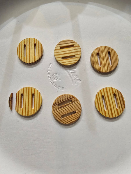 WeatherWool loves to use Slot Buttons, but there are not many factory-made choices, so we are working on our own. These are made from antique wood, which is evidently not strong enough, as button on lower left fractured during shipping